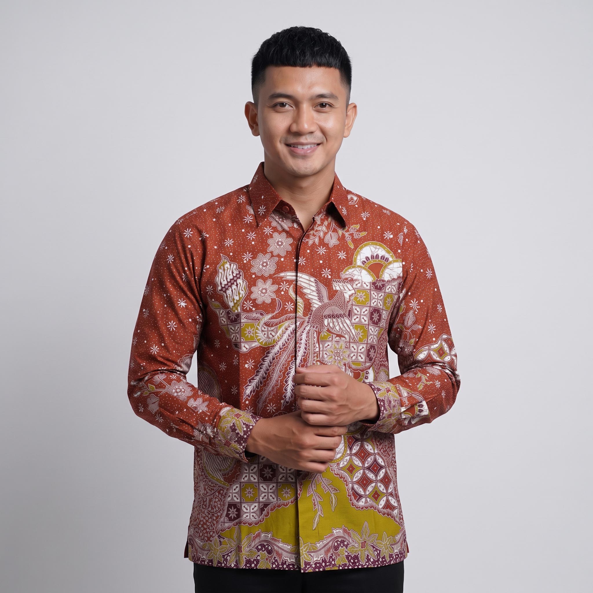 Kemeja batik pria lengan panjang katun premium warna merah bata motif garuda dengan jahitan clean look.